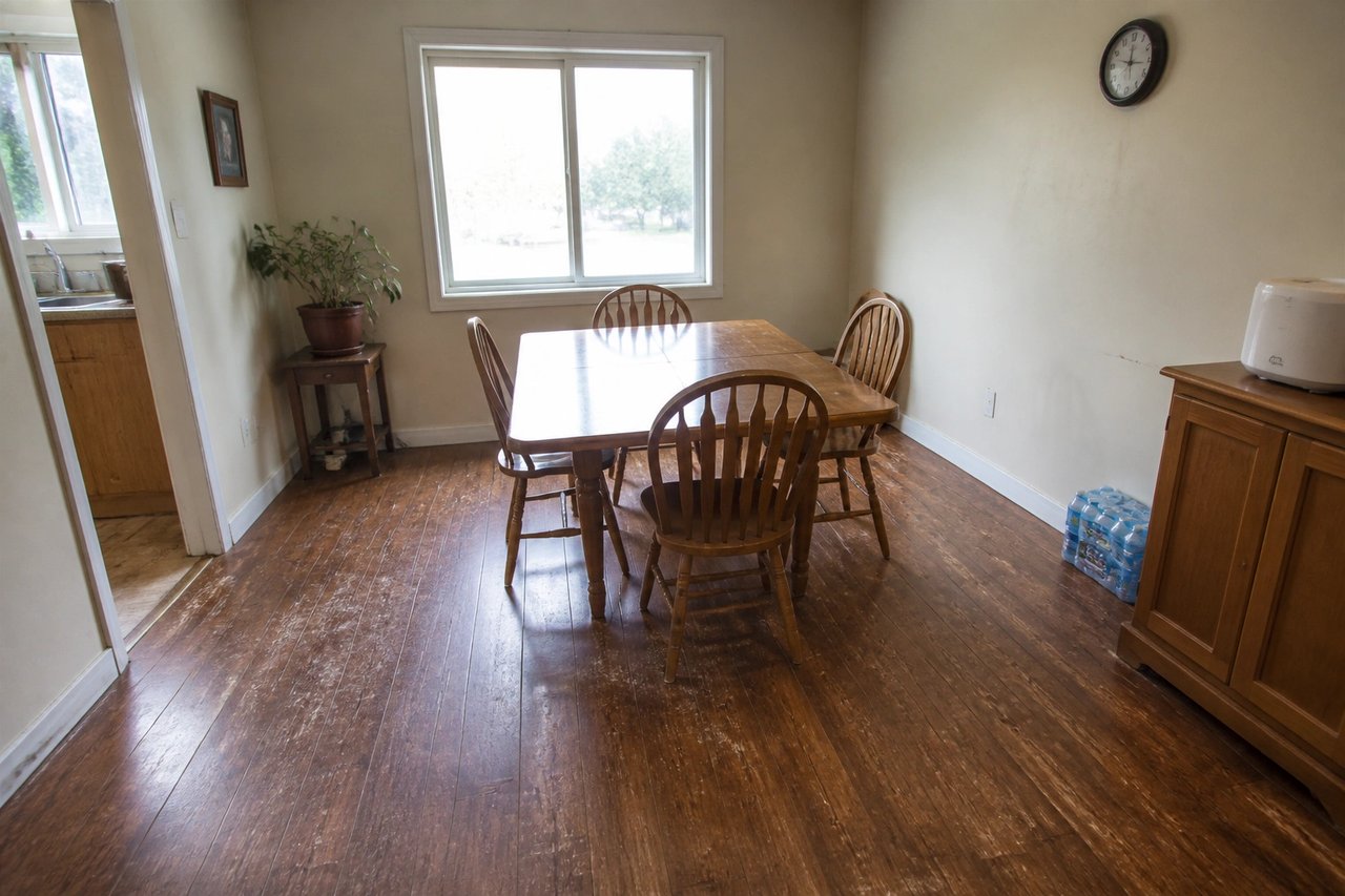 Dining room with worn laminate floor before AI redesign